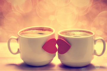 Two coffee cups with red hearts as a kissing lips
