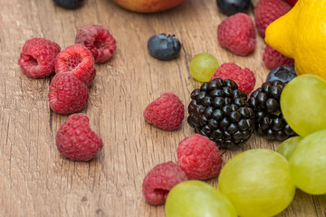 Lemon, Grapes And Berries Summer Fruits On Wood Table