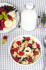 granola with fruits and bottle of fresh milk