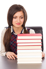 Portrait of a schoolgirl looking to a stack of books