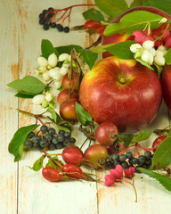 image of red apples and berries on a wooden table closeup