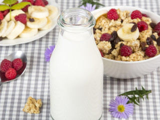 bottle of fresh milk and granola with fruits