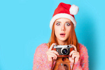 Redhead girl in hat and camera on yellow background.