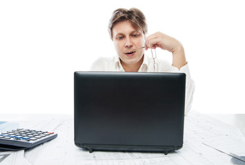 Thinking young office worker with laptop isolated