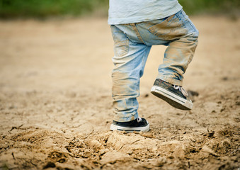 Detail of little boys legs in mud