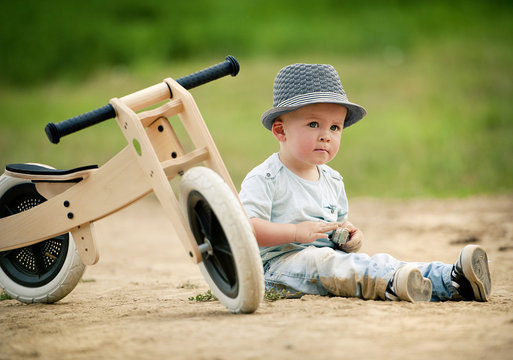 Little boy with tricycle in nature