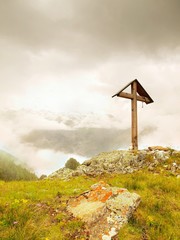 Wooden cross at a mountain top in the alp. Cross on peak of hill