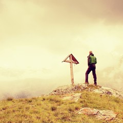 Obraz premium Tourist stand on rocky view point and watching into misty Alpine