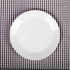 white plate on checkered table cloth - kitchen background
