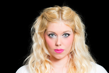 Blonde Frau mit blauen Augen vor schwarzem Hintergrund