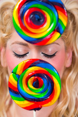 Blonde Frau mit blauen Augen und Lollipops in der Hand