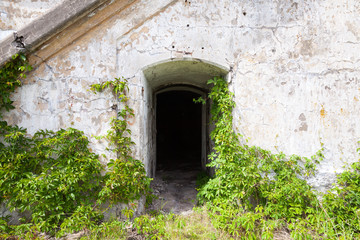 Fototapeta na wymiar Dark empty doorway in old fortification wall, background texture