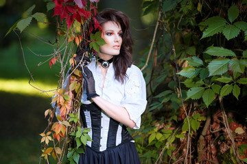 Mysterious woman in Victorian dress among the autumn leaves