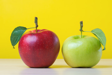 Red and green apples on yellow background