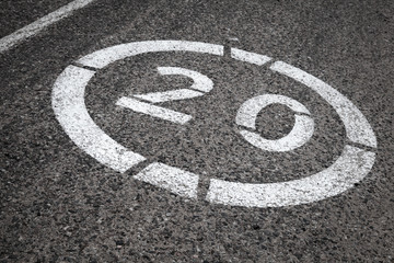 Speed limit road sign on gray asphalt