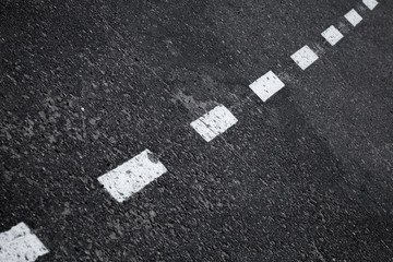 Dark asphalt road background with striped dividing marking line