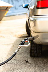 car at gas station being filled with fuel