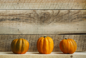 Three Pumpkins on Old  Wooden Background