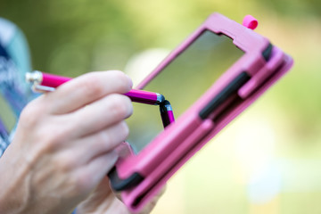 Woman writing on a tablet with a stylus