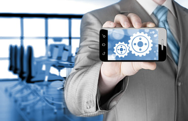 businessman show gear on smartphone to success concept