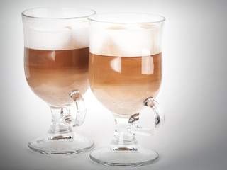 Two glass mugs with handles of latte coffee