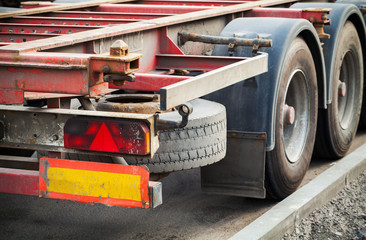 Back part with taillight of empty truck cargo trailer on asphalt