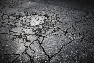 Dark asphalt road with cracks. Background texture