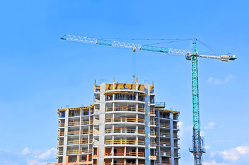 Crane and building construction site against blue sky