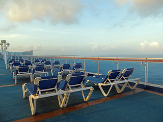  Lounge chairs on a cruise ship deck overlooking the ocean      