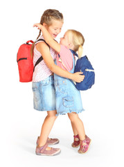 Two sisters with school bags going to school together.