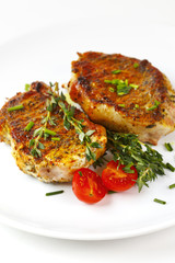 Fresh roasted pork steaks on white plate
