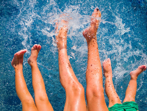 Close-up Of Feet Of Family In The Pool