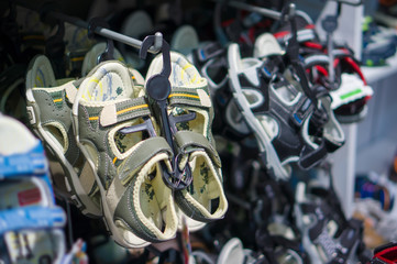 Fototapeta premium Different colors and kinds sandals for kids in stand in footwear