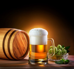 Beer barrel with beer glass on a wooden table. The dark backgrou