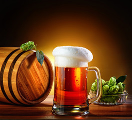 Beer barrel with beer glass on a wooden table. The dark backgrou