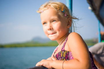 Adorable girl see out to water on upper deck of ferry boat betwe