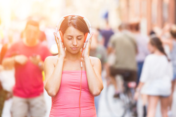 Beautiful Young Woman Listening Music in the City