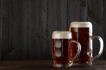 Beer glasses on table, dark wooden background with copy space