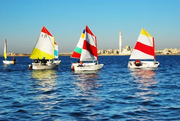 Cercles muraux Naviguer Сhildren learn to sail on Optimist Sailboat