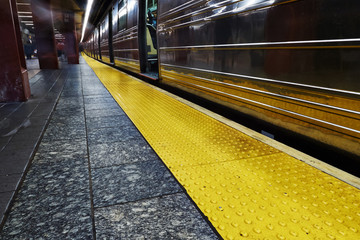 Subway platform with yello line and approaching train