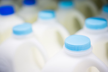 Bunch of milk bottles on fridge shelf in supermarket