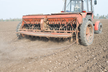 Obraz premium tractor and seeder planting crops on a field