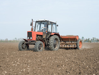 tractor and seeder planting crops on a field