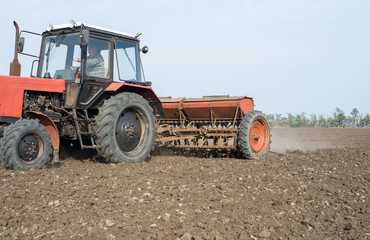 Obraz premium tractor and seeder planting crops on a field