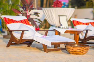 Luxury beach chair and bowl with flowers on tropical island beac