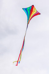 Rainbow Kite flying against a cloudy sky.