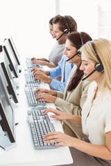 Business people with headsets using computers in office