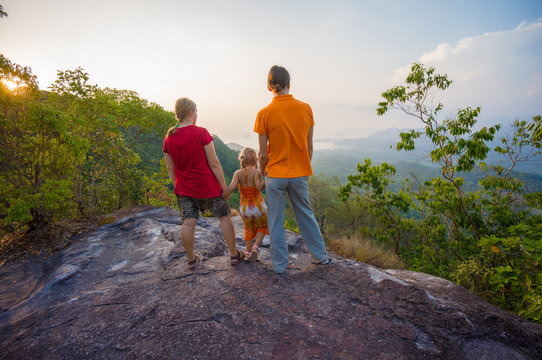 Family stay near cliff on the top of tropical island mountain on