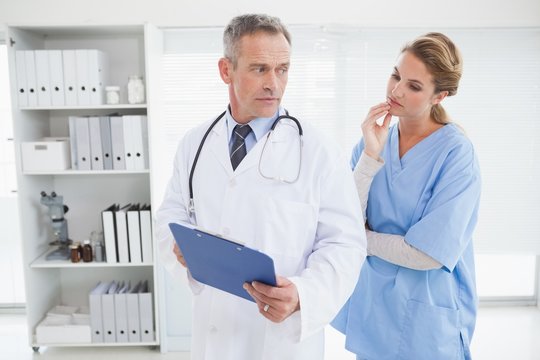 Serious doctor showing nurse a chart
