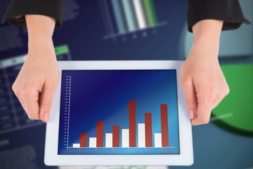 Composite image of businesswomans hands holding tablet